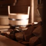 Stove with hot rocks and bucket in sauna