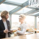 Young waitress listening to her employer during discussion of her working duties